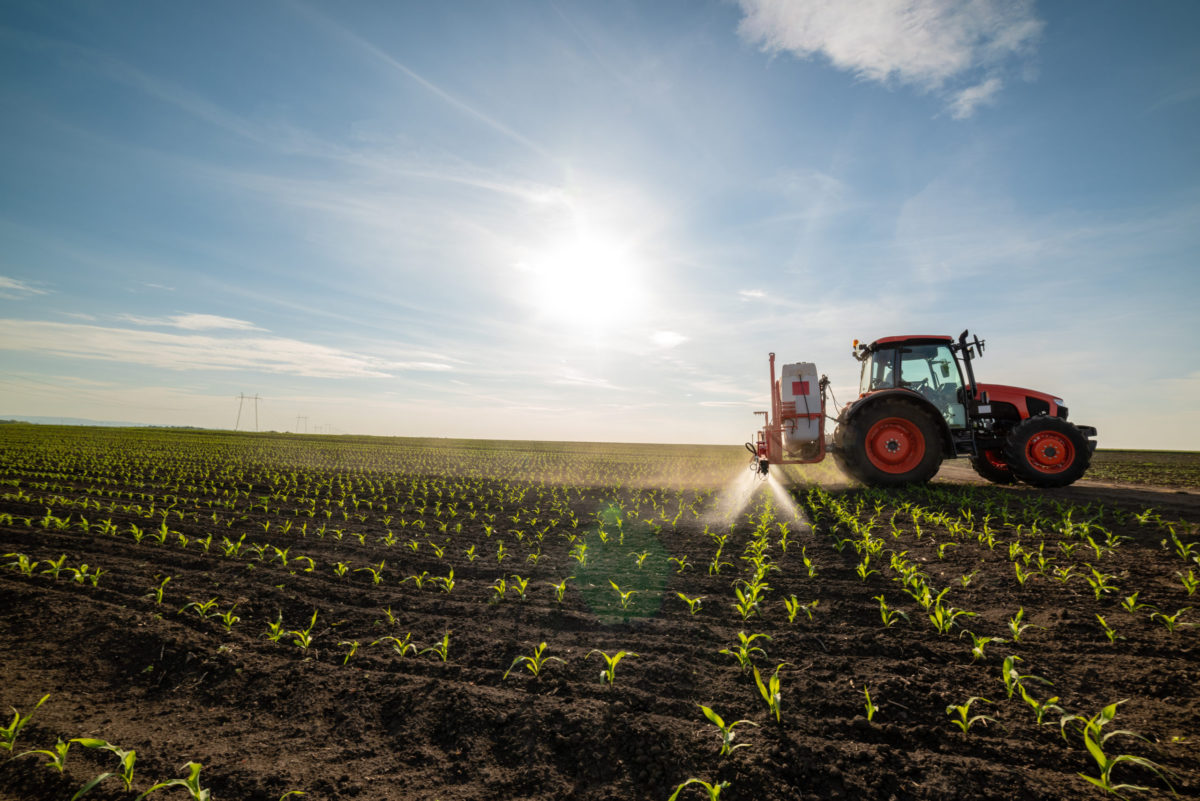 Tractor spraying fields with fertilizers made with sulfur